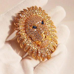 Luxury gold lion head brooch with sparkling cubic zirconia and blue gemstone eyes