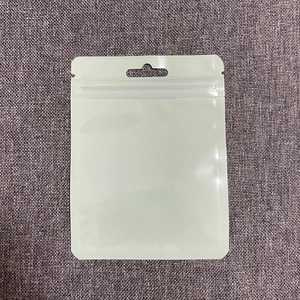 Top-down view of a clear plastic self-sealing bag with a hanging hole on grey fabric