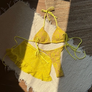 Détail du bikini 3 pièces en dentelle jaune avec jupe à volants et motifs floraux