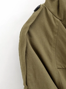Detail of olive green jacket featuring shoulder epaulet and twill cotton fabric texture