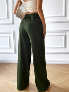 Detailed back view of deep green wide-leg trousers with elastic waist and textured fabric