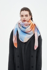 Detail of soft plaid scarf in pink, blue and orange worn with a dark grey coat