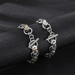 Detail of interlocking Byzantine chain necklaces with toggle clasps in silver and gold tone