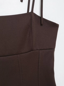 Detail of slim straps and brown elastic fabric with a neat bow on a fitted top