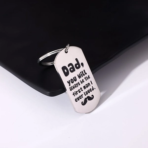Close-up of polished stainless steel dog tag keychain with Dad engraved message and gift ring