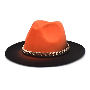 Détail d'un chapeau fedora montrant une calotte orange, un bord noir et une chaîne dorée