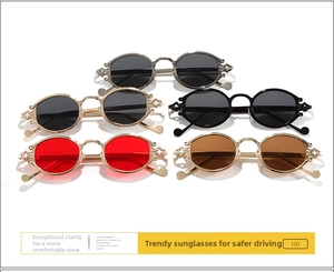 Detail of five punk oval sunglasses with ornate cross-engraved metal temples and tinted lenses