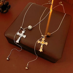 Detail view of silver and gold cross necklaces with tiger eye beads on brown leather
