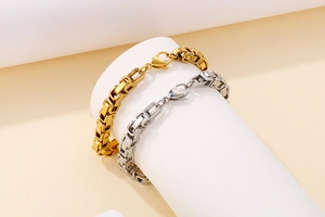 Gros plan de bracelets gourmettes cœur évidé en or 18k et argent sur présentoir blanc