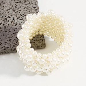Detailed view of multi-layer elastic pearl wide bracelet set on grey volcanic rock