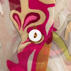 Close-up of paisley chiffon shirt featuring white buttons and abstract floral textile