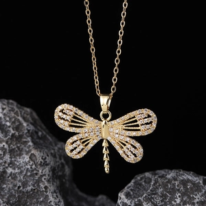 Detailed close-up of golden dragonfly pendant necklace with white zircon pavé setting