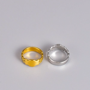 Macro shot of gold and silver stainless steel rings with hollow textures and wave patterns