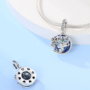 Dettaglio charm colibrì in argento con smalto blu, foglie verdi e cristalli colorati