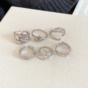 Detail view of 6-piece silver textured resin and crystal rings on woven background