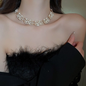 Close-up of layered gold pearl necklace with crystal accents on a female model neck