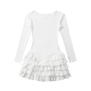 Detail of white long sleeve dress showing multi-layered ruffle hem and cotton fabric texture