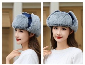 Detail of dark blue winter trapper hat with thick grey faux fur lining and ear flaps