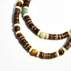 Macro shot of tiger eye stone beads and coconut shell discs on a beaded necklace