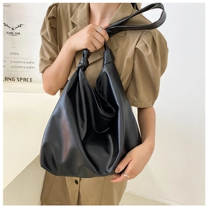 Detail of black large capacity tote bag featuring creative knot handle design and soft texture
