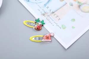 Close-up of Christmas BB hair clips featuring reindeer and Santa bear icons with glitter