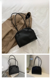 Minimalist black leather tote bag shown with brown blazer in a lifestyle aesthetic setting