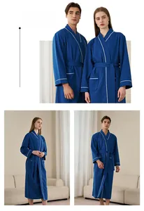 Detail of dark blue waffle weave bathrobe featuring white trim and functional pockets