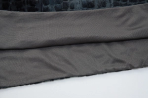 Detailed macro view of dark blue velvet crocodile texture stitched with grey elastic fabric