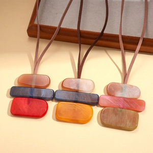 Three colorful acrylic geometric block pendant necklaces on brown faux suede cords