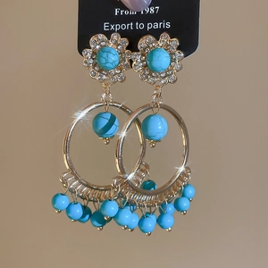 Detailed view of vintage gold tassel earrings with turquoise beads and crystal accents