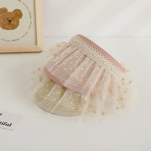 Detail of pink and beige kids' straw sun visors with polka dot mesh and lace trim decoration