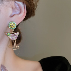 Detail showing cocktail glass earrings with lemon slice studs on a model’s ear