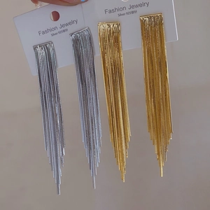 Detaillierte lange Quasten-Ohrringe in Silber und Gold auf einer Displaykarte präsentiert
