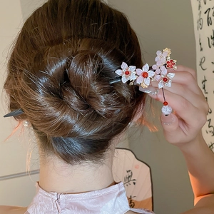 Close-up of a floral butterfly tassel hairpin styled in a traditional bun hairstyle