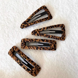 Detailed set of four leopard print fabric covered hair clips in rectangle and water drop shapes