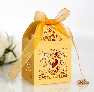 Macro view of gold laser-cut heart pattern gift box with elegant yellow organza ribbon