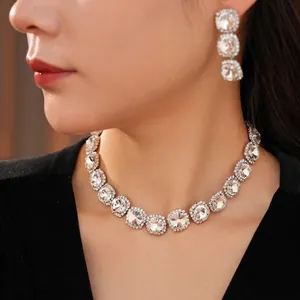 Sparkling silver necklace and earrings set with square rhinestones worn by a model