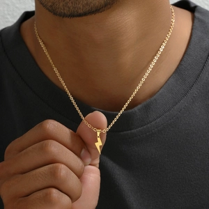 Golden lightning bolt pendant necklace in stainless steel shown on female model