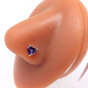 Detailed view of a gold-plated heart-shaped purple zircon nose stud on a display model
