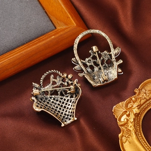 Vintage gold flower basket brooch set with safety pin on silk fabric background