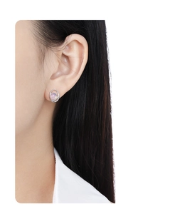 Dettaglio di un orecchino geometrico in argento con opale rosa indossato da modella
