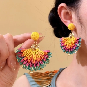 Detailed view of colorful raffia fan-shaped drop earrings for vacation style.
