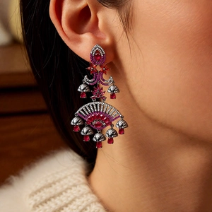 Close-up of elegant red gemstone chandelier earrings with fan-shaped ethnic design