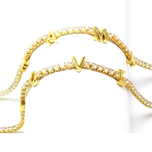 Detail of gold-plated tennis bracelets featuring LOVE MAMA zircon letter charms