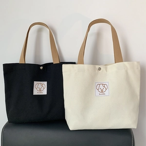 Close-up of canvas handbags with lovable cartoon patches and sturdy woven handles