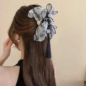 Detail of vintage bamboo print hair claw with white rose and long black tassel