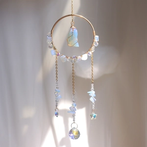 Golden suncatcher featuring an opal gemstone, faceted crystal ball, and star pendant detail