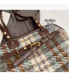 Detail shot of checkered wool tote bag featuring brown leather trim and gold metal studs