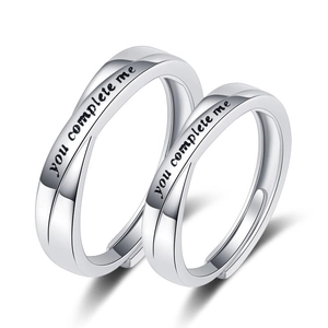 Silberne Mobius-Paarringe mit 'you complete me' Gravur auf einem rein weißen Hintergrund