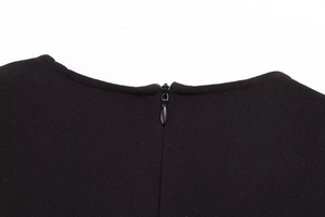 Detailed close-up of the hidden zipper on the back neckline of this black midi dress